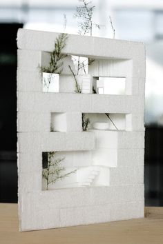 a white sculpture with plants growing out of it