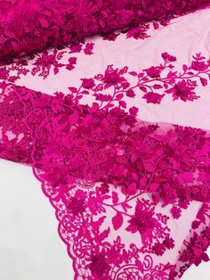 three pieces of pink lace with flowers and leaves on the edge, one piece has been cut