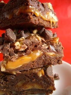 three brownies stacked on top of each other with chocolate and caramel toppings