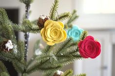 colorful felt flowers are on the top of a christmas tree