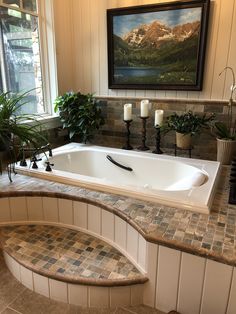 a bathroom with a large jacuzzi tub next to two candles on the counter