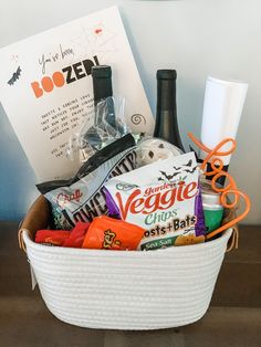 a white basket filled with candy and snacks next to a halloween sign on the wall