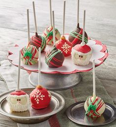 several desserts are arranged on trays with christmas decorations