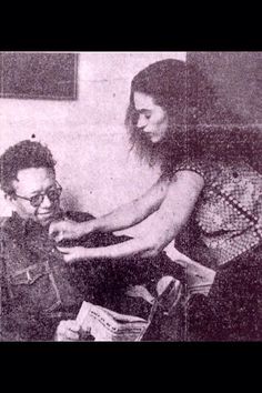 an old black and white photo of a man sitting next to a woman