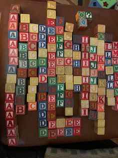 the letters are made from wooden blocks and placed on top of a brown leather suitcase