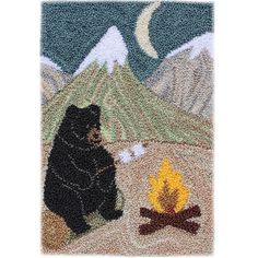 a bear is sitting next to a campfire