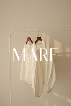 two shirts hanging on a clothes rack with the word mare above them that reads,