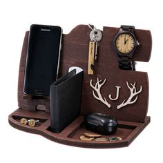 a cell phone, wallet, watch and other items are arranged on a wooden stand