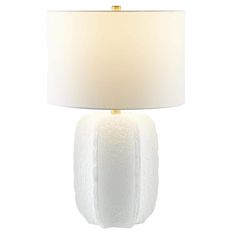 a white table lamp with a gold base and a light shade on the top of it