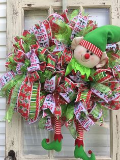 a christmas wreath with a teddy bear and candy canes attached to the front door