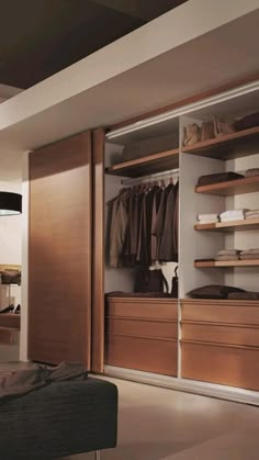 an open closet is shown with clothes and shoes on the shelves in front of it