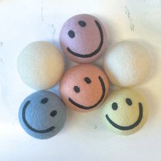 four balls with smiley faces painted on them