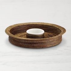 a bowl sitting on top of a wicker tray next to a marble countertop