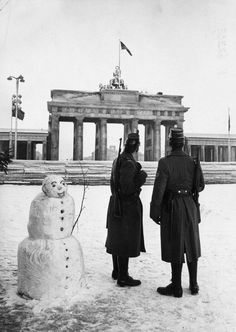 two men standing next to a snowman in front of the berliner dommer