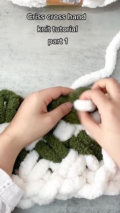 someone is crocheting some white yarn on a blanket with green and white colors