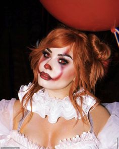 a woman dressed as a clown holding a red balloon