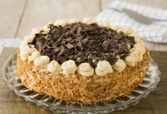 a cake sitting on top of a glass plate covered in chocolate and white frosting