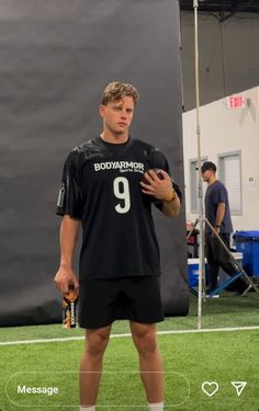 a man standing on top of a soccer field holding a ball in his right hand