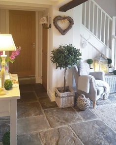 a living room filled with furniture next to a stair case covered in flowers and greenery