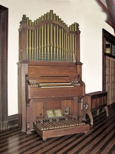 an old pipe organ sitting on top of a hard wood floor