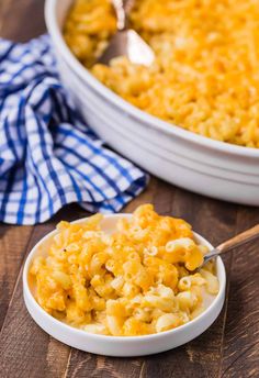 a white bowl filled with macaroni and cheese on top of a wooden table