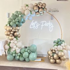 an arch made out of balloons with the words let's party written on it