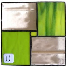 a green and white tile with the letter u on it