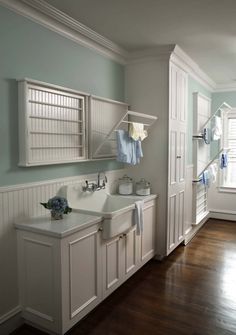 an image of a bathroom with white cabinets and green towels on the rack above the sink