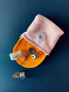 an orange and white case with some tools in it on a blue surface next to a pair of scissors