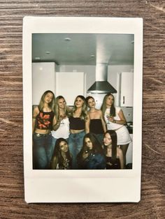 a group of women standing next to each other on a wooden table in front of a stove top oven