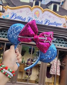 someone is holding onto the ears of minnie mouse ear headbands at disneyland world