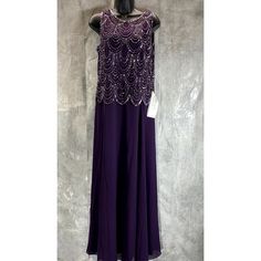 a purple dress with sequins and beads on the neckline, hanging from a mannequin head