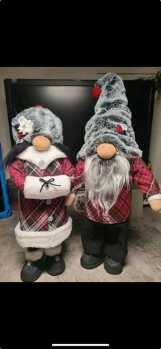 two christmas gnomes standing next to each other