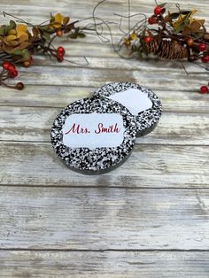 two black and white cookies sitting on top of a wooden table next to christmas decorations