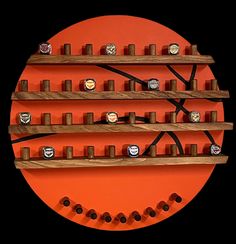 an orange circle with several wooden shelves on each side and five rings in the middle