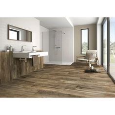 a bathroom with wood flooring and white walls, along with a large window overlooking the outdoors