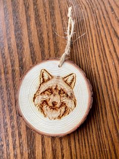 a wooden ornament with a drawing of a fox on it's face