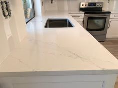 a kitchen with white counter tops and stainless steel stove top oven in the center island