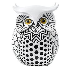 an owl figurine sitting on top of a white surface with black and white dots