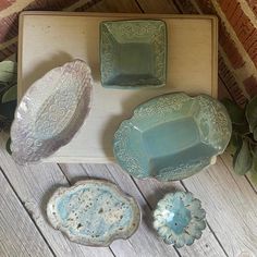 four pieces of pottery sitting on top of a wooden table