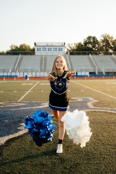 a cheerleader is running on the field with her pom poms in hand