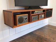 an entertainment center with speakers and a television on it's stand in front of a wall