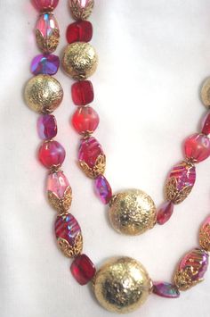 "Vintage Beaded Choker / Necklace: Two-Strand Pink & Red Glass with Gold Metal Accent Beads Unusual 1950s-1960s Pretty 50s-60s necklace, with gorgeous pink and red glass beads of various shapes and types with different sizes of round gold metal beads and chunky gold chain. Hook clasp; unmarked. This necklace is truly gorgeous--the beads sparkle and shimmer. 17\" long / 20.5\" long with extender...this is a choker." Vintage Red Necklace For Celebration, Red Vintage Necklace For Celebration, Vintage Red Necklace With Colorful Beads, Vintage Red Necklaces With Colorful Beads, Vintage Large Beads For Festive Occasions, Retro Red Necklace For Party, Vintage Red Jewelry For Celebrations, Red Vintage Jewelry For Celebrations, Festive Vintage Large Beads