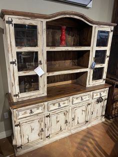 an old white china cabinet with glass doors