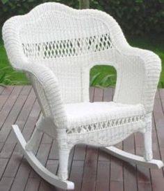 a white rocking chair sitting on top of a wooden deck