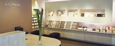 the front desk of a book store with many books on shelves and a vase filled with flowers