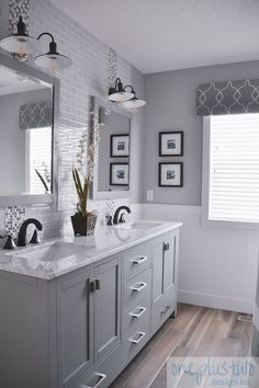 a large bathroom with two sinks, mirrors and pictures on the wall above it's countertop