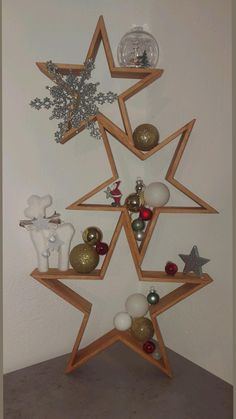 a christmas tree made out of wooden shelves with ornaments on top and around the edges