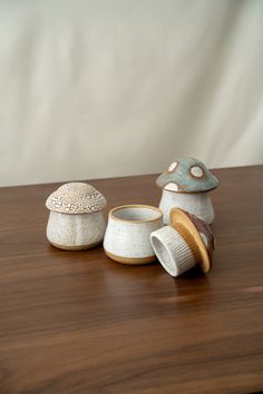 three ceramic objects sitting on top of a wooden table