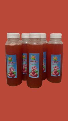 three bottles of juice are shown on a red background with the same color as the image